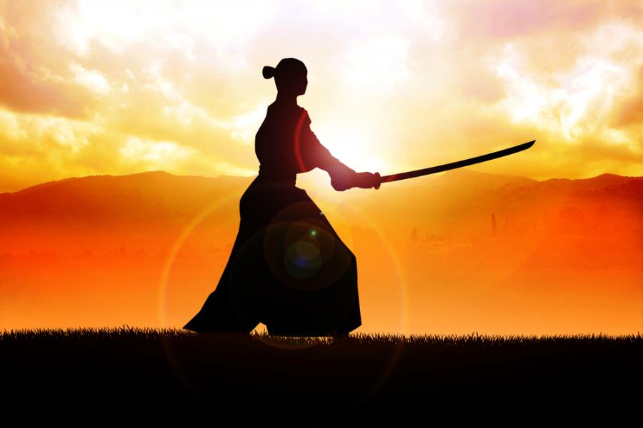 Фото: Silhouette of a samurai posing during sunset.